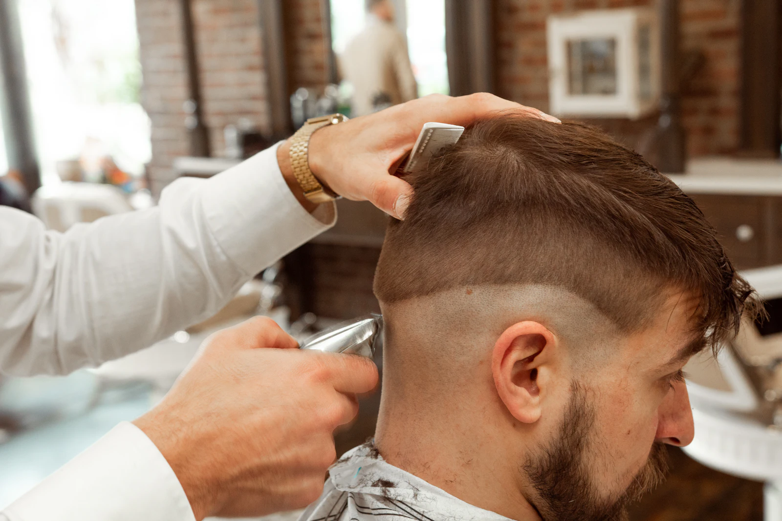 A barber trimming a client's fade