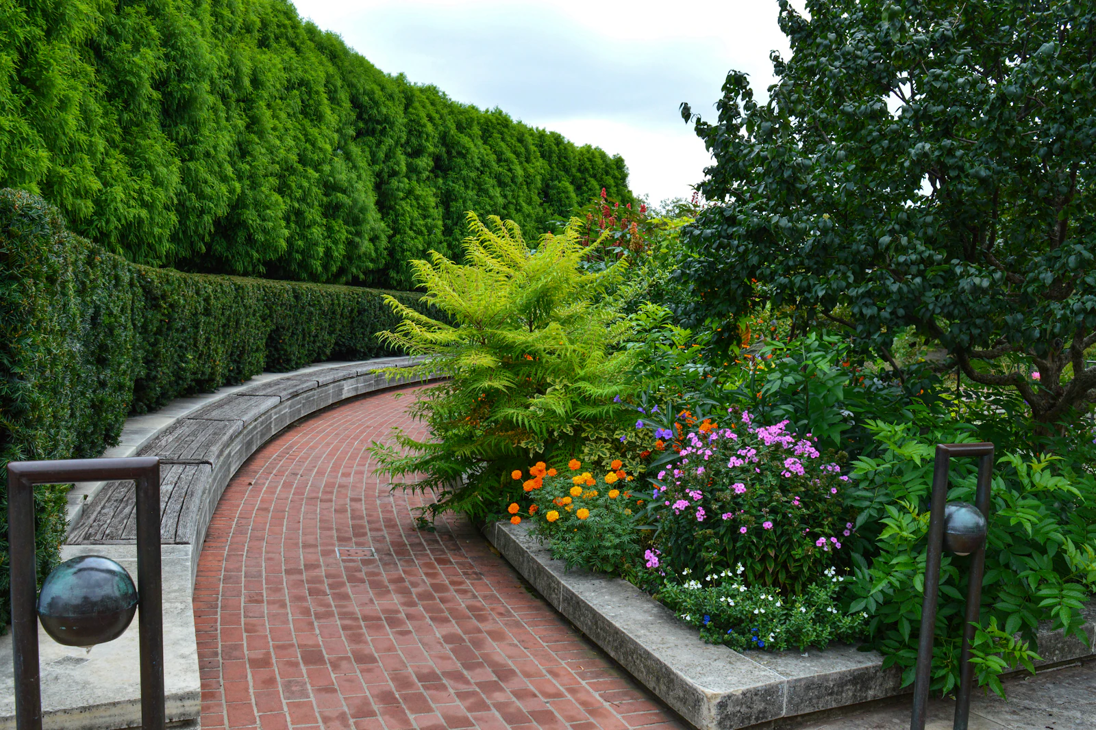 A curving brick path through lush garden beds